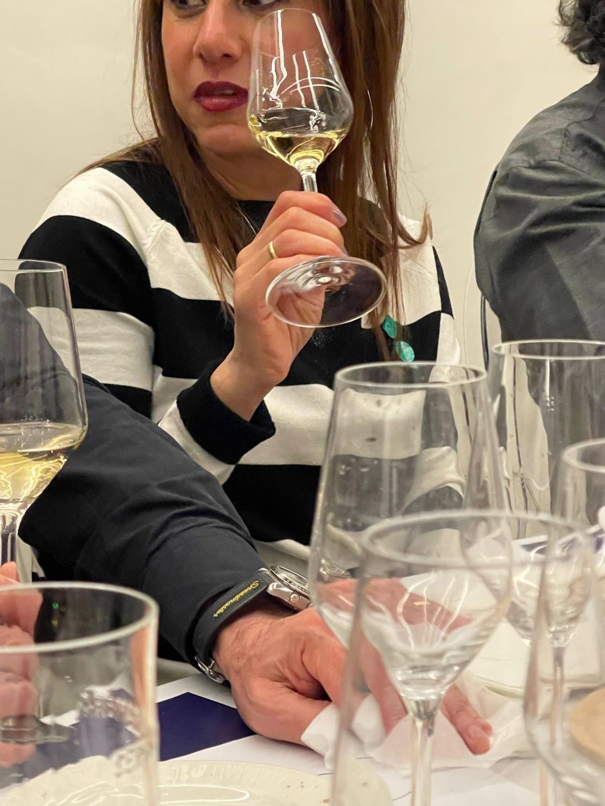 Asistente catando una copa de vino blanco